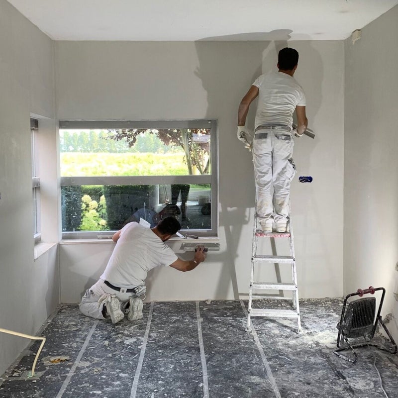 Twee stukadoors van Umut58 werken een wand strak af in een lichte woning